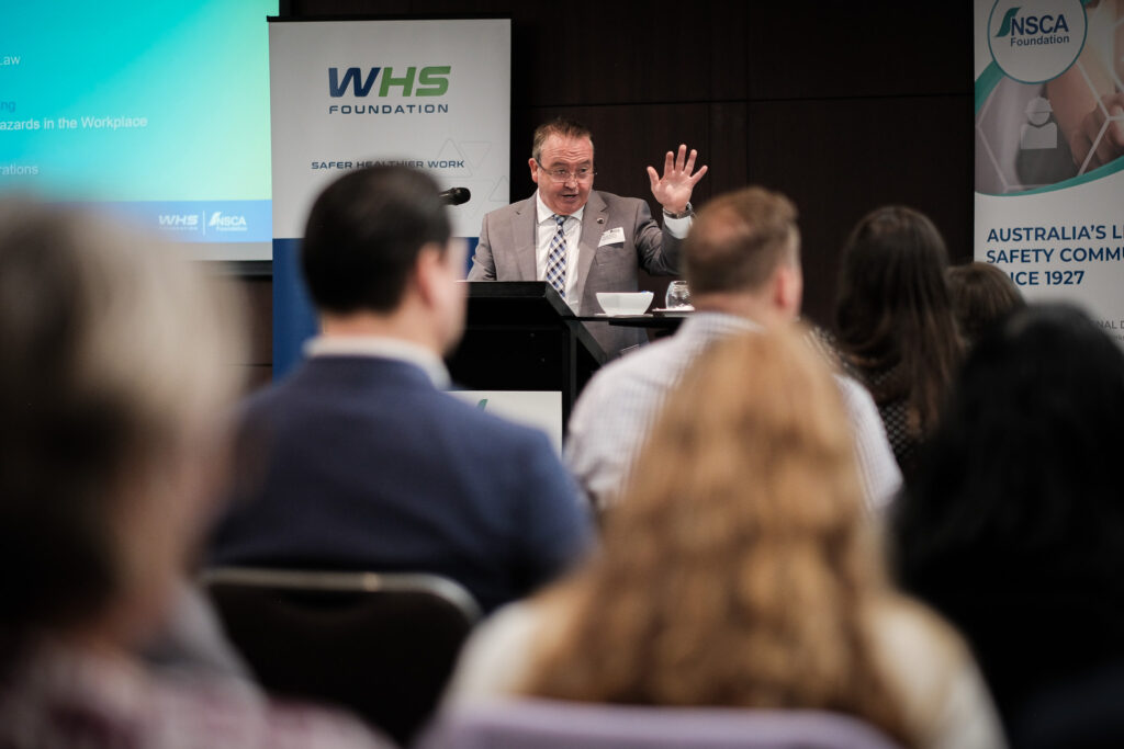 Michael Morgan, Managing Director, WHS Foundation is standing at a lectern presenting at the Perth Safety Forum